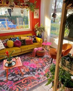 a living room filled with furniture and lots of plants on the windows sills