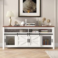 a living room with a white cabinet and bookshelf next to a painting on the wall