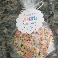 there is a bag of sprinkles in the shape of a heart with a tag on it