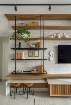 a living room filled with furniture and a flat screen tv on top of a wooden shelf