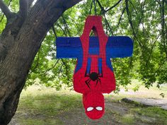 a spiderman cross hanging from a tree