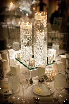 the table is set with candles, plates and silverware for an elegant wedding reception