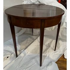 a wooden table sitting on top of a white sheet