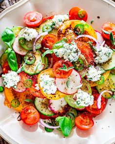 a white plate topped with lots of veggies and cheese on top of it