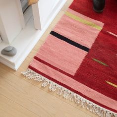 a red rug on the floor next to a white door