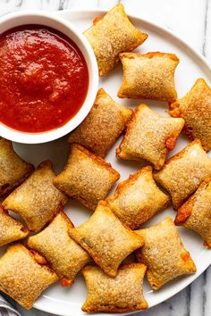 small pastries on a plate with dipping sauce in a bowl next to the food