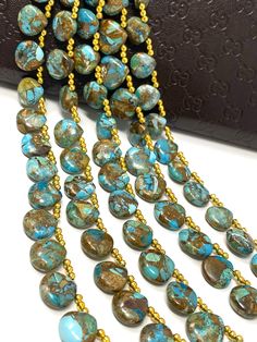 a long necklace with many beads hanging from it's end, and two strands of turquoise