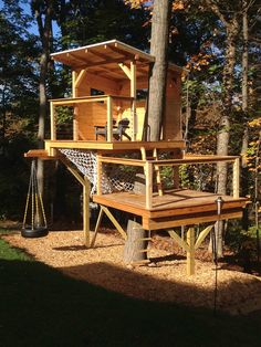 a tree house built into the side of a wooded area with a hammock