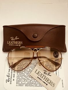 Please read all the description and check all photos before buying . you are buying a new old stock  vintage aviator outdoorsman shooter leather  ray ban sunglasses bausch & lomb  b&l usa  in new condition  size 62mm  [ large size ]   lenses are brown changeable photochromic self changing   in new mint condition without any scratches . on the top of bridge reads " bl ray ban usa " frame is gold and  brown perforated leather ,, limited edition leather ,, very pretty  ray ban logo on the right len Retro Brown Aviator Sunglasses, Cheap Vintage Aviator Sunglasses, Cheap Retro Brown Aviator Sunglasses, Luxury Vintage Aviator Sunglasses For Summer, Luxury Casual Brown Aviator Sunglasses, Luxury Vintage Men's Sunglasses, Vintage Brown Aviator Sunglasses, Luxury Vintage Aviator Sunglasses With Tinted Lenses, Luxury Brown Aviator Sunglasses