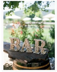 the word dad spelled with beads sits on top of a barrel