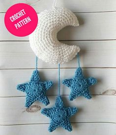 crocheted stars and moon hanging from string on white wooden background with wood planks