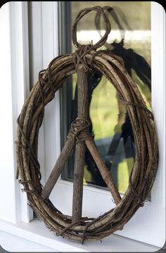 a peace sign made out of branches on a window sill