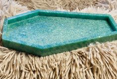 a green tray sitting on top of a pile of fur