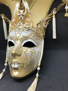 Venetian Mask for decoration - Traditional and original papier-mache Venetian mask, handmade and decorated with metal insert, gold-leaf and glitters,enriched with Swarovski crystals. dimensions::Hight 43cm,width 27cm Decorations only,Not wereable All our masks are handmade papier-machè masks made in Venice. Our decorators use techniques typical of the Venetian tradition such as stucco, acrylics, gold and silver-leaf, macramè, passementerie, glitters and crequelè to offer you a wide range of orig Artistic White Masks And Prosthetics For Mardi Gras, Artistic White Masks For Mardi Gras, Gold Venetian Mask For Halloween, Venetian Masks And Prosthetics For Carnival, Venetian Masks For Carnival Themed Events, Venetian Masks For Themed Carnival Events, Venetian Mask For Mardi Gras, Venetian Masks And Prosthetics For Mardi Gras, Venetian Masks For Mardi Gras Carnival