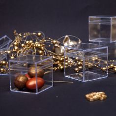 three clear cubes with gold decorations on the floor next to each other and one is empty