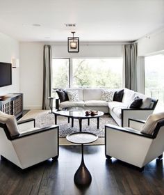 a living room filled with furniture and a flat screen tv mounted on the wall above it