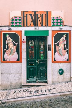 an entrance to a building with two doors and paintings on the side of it's wall