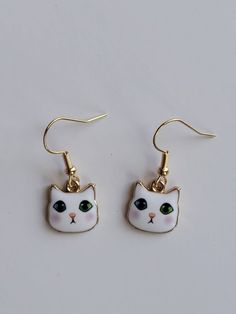 Who doesn't love odd-eyed cats?! No one I know! They are the coolest looking cats! These cute, odd-eyed cat earrings feature a sweet, white cat with one blue eye and one green eye. These cute earrings are small and lightweight making them ideal for adults, teens, and kids. The drop length is almost 1 inch. The width and length of the earring is about .5 inches. The ear wires are hypoallergenic and nickel-free. Each pair comes with two clear, rubber earring backs. These cute cat earrings are wrap Sweet Kitty, Green Eye, Fun Jewelry, Cat Jewelry, Blue Eye, Earrings White, Cat Earrings, Fun Earrings, Cute Earrings