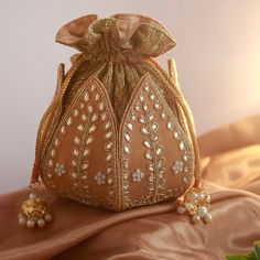 Discover the Elegant Lotus Potli Bag by THE TAN CLAN Elevate Your Style with Our Unique Embroidered Indian Bridal Potli Bag by THE TAN CLAN Transform your accessory collection with the Elegant Lotus Potli Bag--a stunning fusion of traditional craftsmanship and modern design. This exquisite embroidered potli bag is perfect for weddings, engagements, bridesmaid gifts and anniversary gifts. With its intricate detailing and luxurious finish, this bag is a must-have for anyone looking to add a touch Lotus Potli Bag, Satin Quilt, Potli Bag, Embroidered Clutch, Potli Bags, Diwali Gifts, Indian Bridal, Flap Bag, Aza Fashion