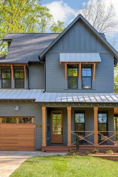 a large gray house with lots of windows on the front and side of it's roof