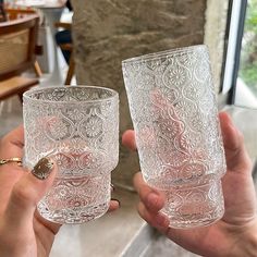 two people holding glasses in their hands