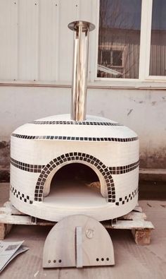 an outdoor pizza oven sitting in front of a building