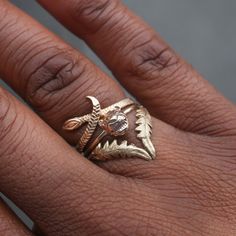 a close up of a person's hand with a gold ring on their finger