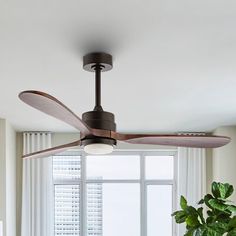 a living room with a large window and a ceiling fan in the middle of it