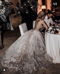 a woman in a wedding dress sitting at a table