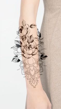 a woman's arm with flowers and leaves on it