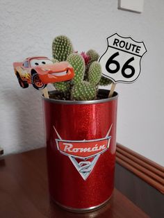 a red tin can with cars on it and a route 66 sign in the background