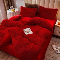 a red comforter set with slippers on the floor