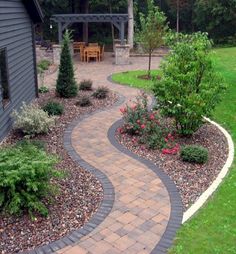 a brick walkway in the middle of a yard