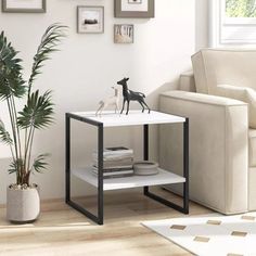 a living room with a couch, table and pictures on the wall