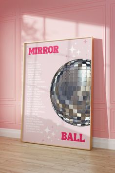 a mirror ball on the floor in front of a pink wall