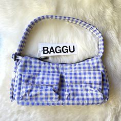 New With Tag. Color: Blue Gingham A Baguette Style Purse With Two External Flap Pockets For Easy Access To Your Essentials. - Two Exterior Flap Pockets With Magnetic Closure - Measures 4.7" H 11" W 3" D - Adjustable 29.5" Quilted Strap - Recycled Heavyweight Nylon With Recycled Ripstop Lining - Machine Washable ** First Time On Poshmark? Use Code Emmmamercer When You Create Your Poshmark Account To Receive A $10 Credit Toward Your First Purchase. ** Baggu Bags, Blue Gingham, Blue Bags, 7 H, Magnetic Closure, Flap Pocket, Easy Access, Gingham, 3 D