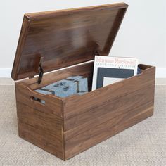 an open wooden box with books inside on the floor