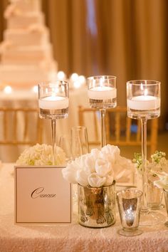 a table topped with lots of white flowers and candles