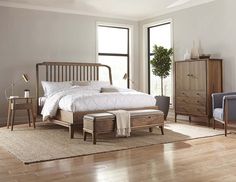 a bedroom scene with focus on the bed, dresser and foot stools in the foreground