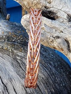 a close up of a piece of jewelry on a tree branch