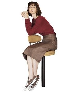 a woman sitting on a chair drinking from a cup