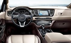 the interior of a car with dashboard, steering wheel and center console in front of an ocean view