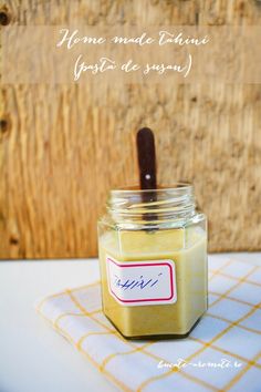 a jar filled with yellow liquid sitting on top of a white and yellow table cloth