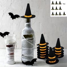 a bottle wrapped in paper and decorated with black witch's hats next to halloween decorations