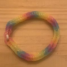 a rainbow colored bracelet on a wooden surface