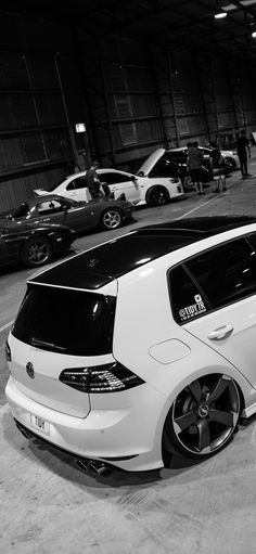 a white car parked in a garage next to other cars