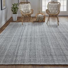 a living room with two chairs and a rug