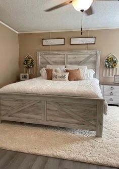 a bedroom with a large bed and white rugs on top of the wooden floor