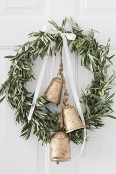 two bells hanging from a wreath on a door