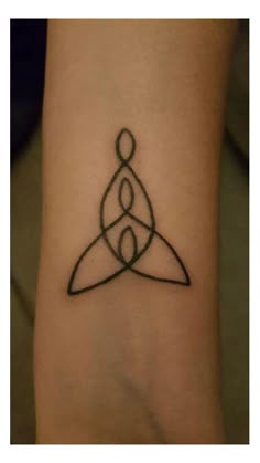 a small tattoo on the wrist that has a triangle and two circles in it,